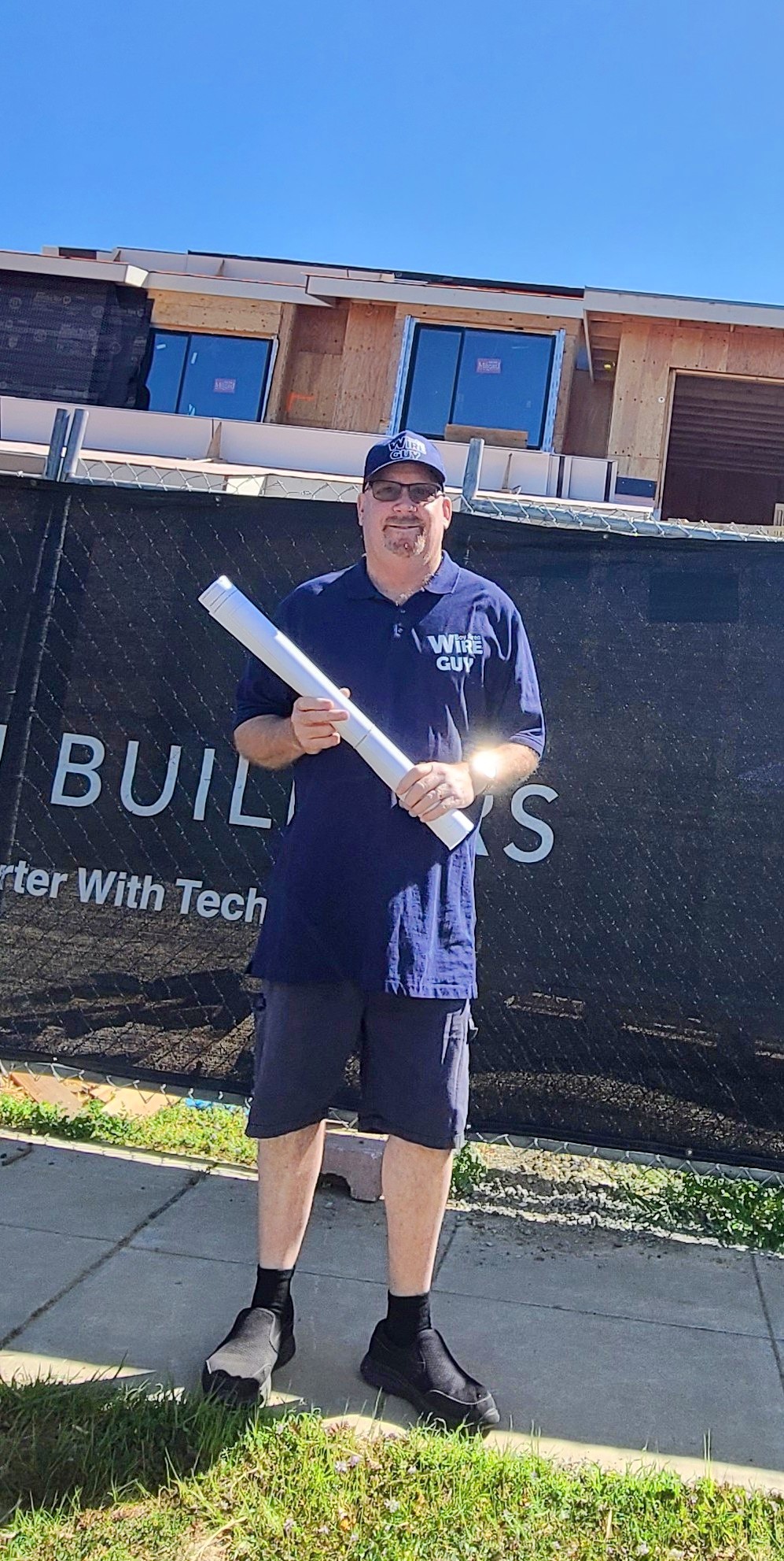 James Miller of Bay Area Wire Guy holding plans at a new-home construction site