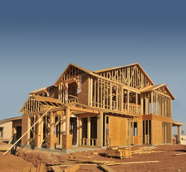 New two-story home with exposed wood framing during construction
